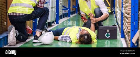 Panoramic Warehouse Worker Do First Aid To His Colleague Lying Down On