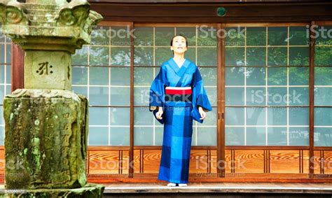 Mature Japanese Female Meditating In Kimono At Buddhist Temple Stock
