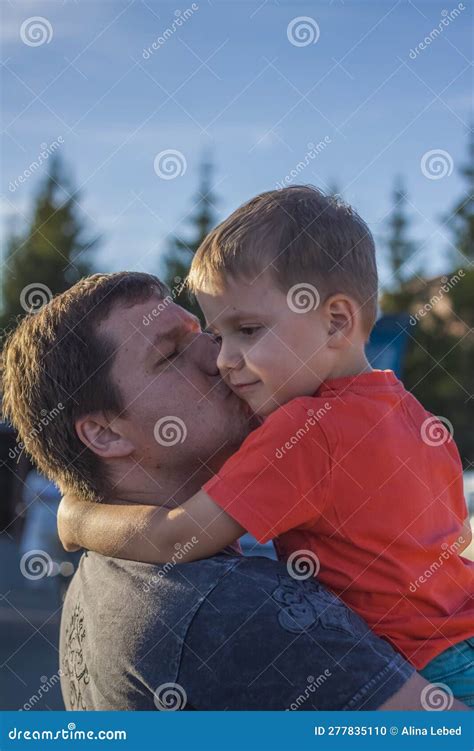 El Padre Abraza Y Besa A Su Hijo En La Mejilla A Quien Sujeta En Los