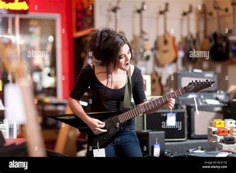 Young Woman Playing Electric Guitar In Music Store Stock Photo Alamy