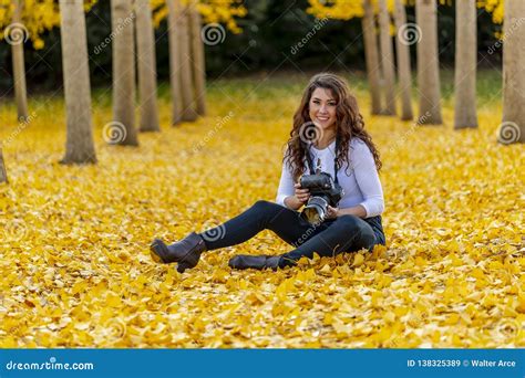 Brunette Model Enjoying A Fall Day In Fall Foliage Holding A Professional Camera Stock Image