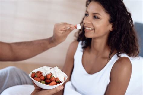 Premium Photo Man Is Feeding His Girlfriend With A Strawberry