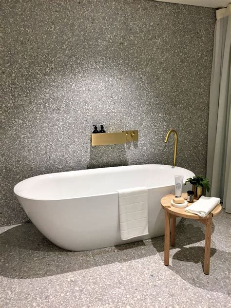 A timber soaking tub adds warmth to the otherwise industrial aesthetic. Large format terrazzo tiles | Terrazzo, Elegant bathroom ...