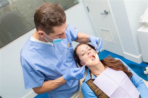 Dentist Performing Teeth Treatment With Female Patient Open Mouth Stock Image Image Of