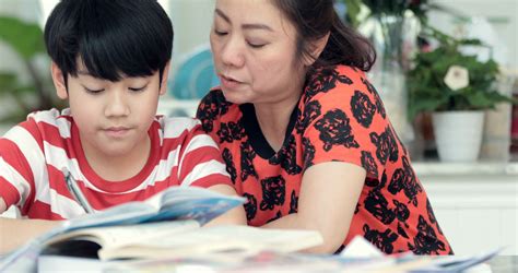 Serious Asian Mother With Son Doing Homework In The Living Room Mom