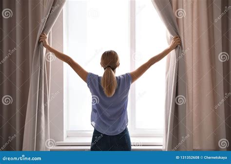 Woman Opening Curtains And Looking Out Of Window Stock Photo Image Of