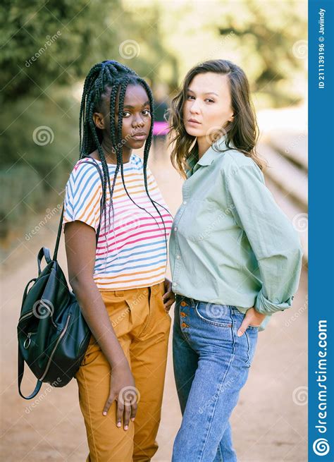 Two Multiethnic Women Looking At Camera Together On The Street Stock
