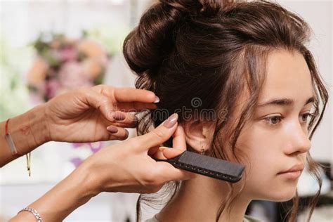 Shooting In A Beauty Salon A Hair Stylist Corrects The Hairstyle Of A Young Dark Haired Girl