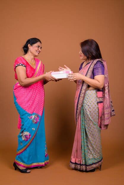 Premium Photo Two Mature Indian Women Wearing Sari Indian Traditional Clothes Together Giving