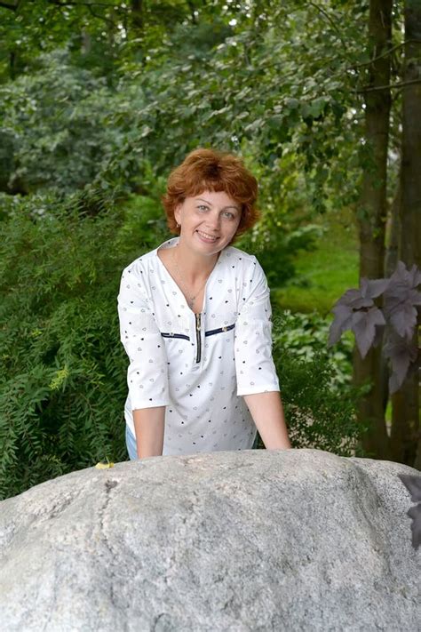 The Woman Of Average Years Leans Hands Against A Boulder Stock Photo