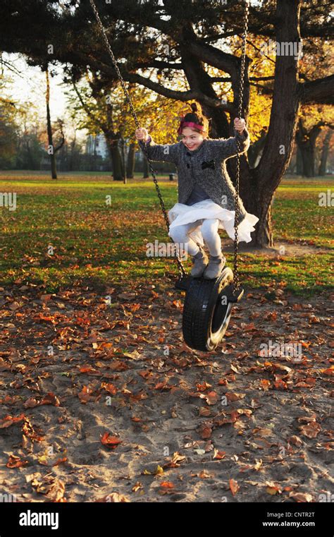 Girl Playing On Tire Swing In Park Stock Photo Alamy