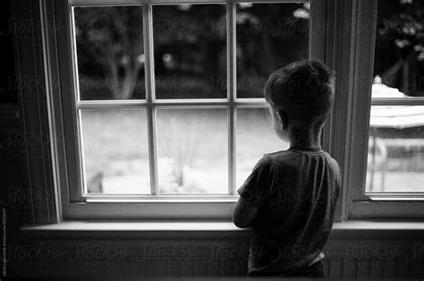 Moody Black And White Images Of A Bored Young Boy Looking Out A Window