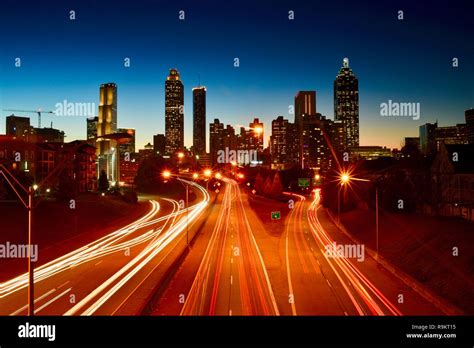 Atlanta Downtown Skyline Lit Up At Sunset Along Busy Highway At Rush