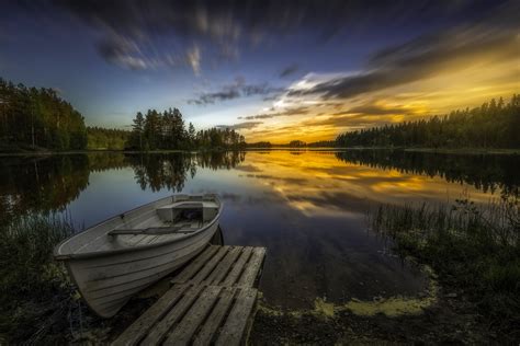 White Boat Beside Brown Wooden Dock In Body Of Water In Timelapse