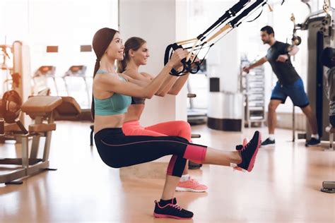 La Gente Se Pone En Cuclillas En El Gimnasio Contra Las Cuerdas Foto