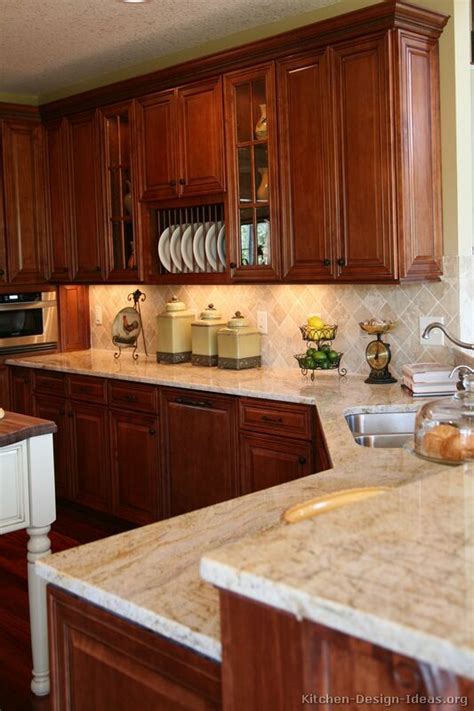 Cabinets with some carves are painted in white and then combined with marble countertop. Cherry Kitchen Cabinets With Gray Wall And Quartz ...