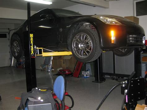 The legs of the hoist go up into an open ceiling. Car Storage Lift Low Ceiling - CARCROT