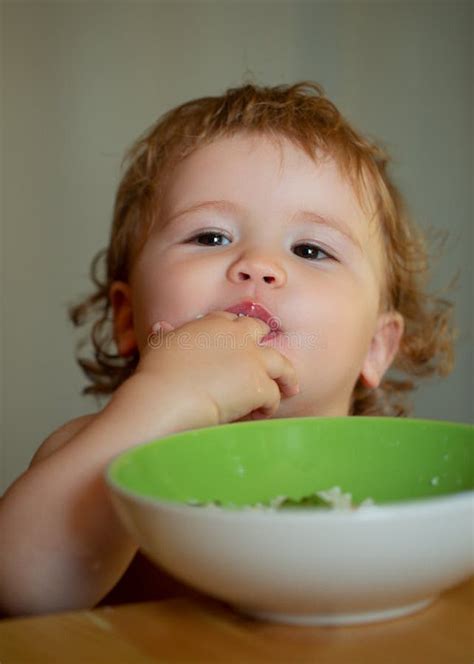 Funny Baby Eating Food Himself With A Spoon On Kitchen Funny Child