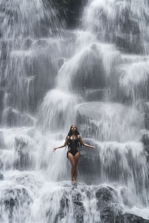 Full Length Portrait Of Attractive Brunette In Black Swimsuit Under Cascade Waterfall Water