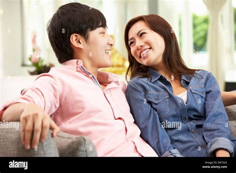 Young Chinese Couple Relaxing On Sofa At Home Stock Photo Alamy