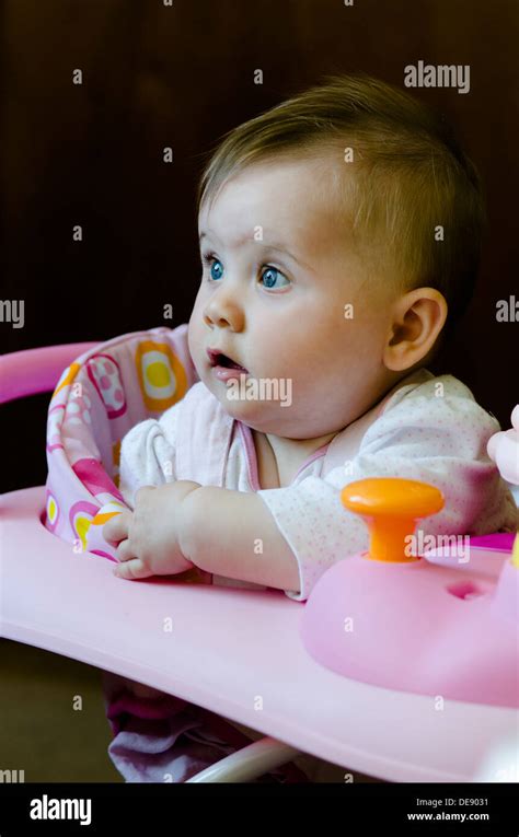 Eight Month Old Baby Girl Sitting In High Chair With Toys Stock Photo Alamy