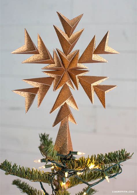 An Ornament Shaped Like A Star On Top Of A Christmas Tree