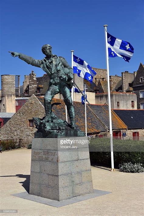 Flag of saint malo flag, city of france, waving in wind. Surcouf statue with quebec flag at Saint Malo city ...