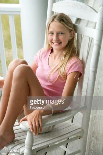 Caucasian Preteen Girl Sitting In Rocking Chair On Porch Smiling Stock