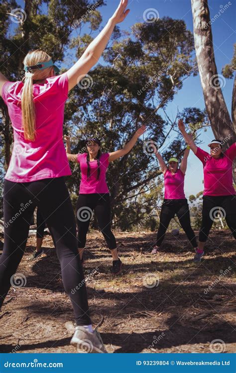 Female Trainer Instructing Women While Exercising In The Boot Camp