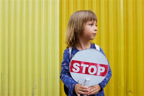 Portrait Of A Child Boy Holding A Stop Sign By Stocksy Contributor