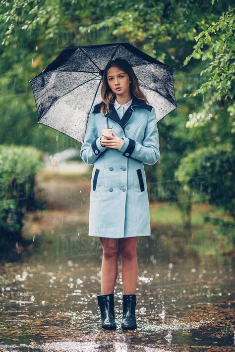 Portrait Of Teenage Girl Holding Umbrella While Standing On Pathway