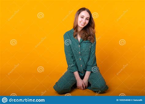 Smiling Young Girl In Pajamas Home Wear Posing While Resting At Home Isolated On Yellow
