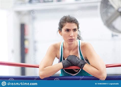 A Badass Female Boxer Is Resting On Ring Ropes With Her