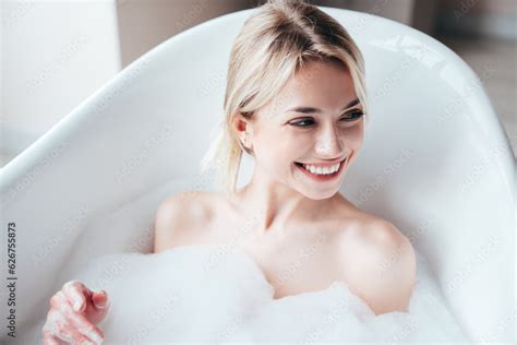Portrait Of Young Beautiful Sexy Woman Having Fun While Lying In Bathtub Full Of Foam At Home