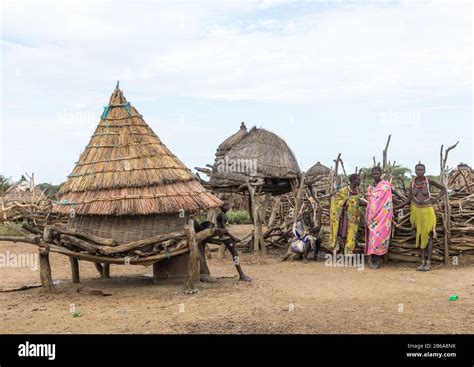 Toposa Tribe Women Standing Near A Granary In A Village Namorunyang