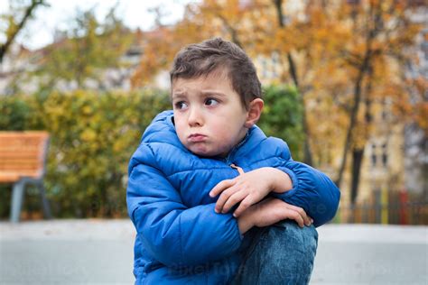 Frowning Little Boy Sitting On Stock Photo Pixeltote