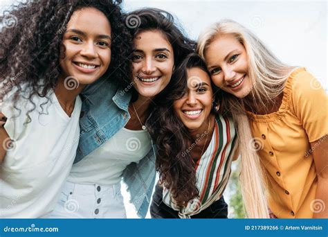 Group Of Happy Young Women Standing Together And Looking At Camera