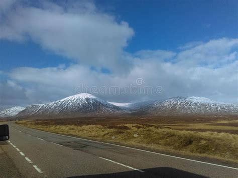 Snow Capped Mountains Of Glencoe Stand Proud Under Breaking Winter Blue