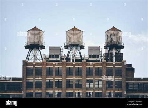 Retro Toned Picture Of Three Water Towers On An Old Industrial Building
