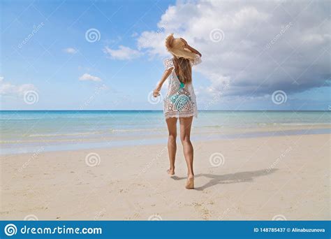Tanned Girl In Blue Bikini And White Tunica Running On The Seashore