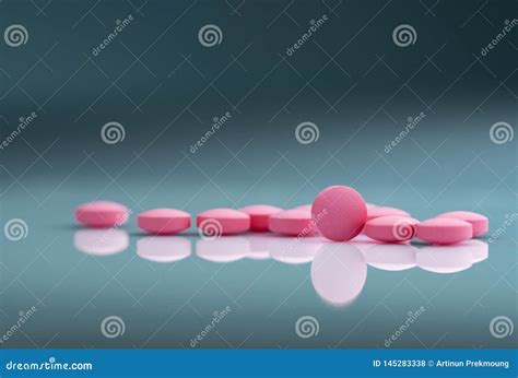 Round Pink Tablets Pill On Blurred Background Of Drug Bottle