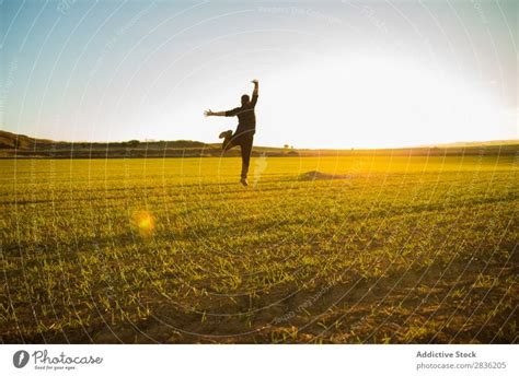 Mann springt auf sonniges Feld - ein lizenzfreies Stock Foto von Photocase