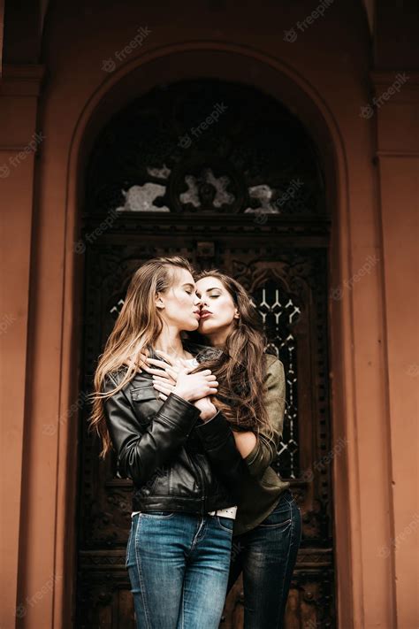 屋外のジーンズで抱き合ったりキスしたりするのが大好きなカップル プレミアム写真