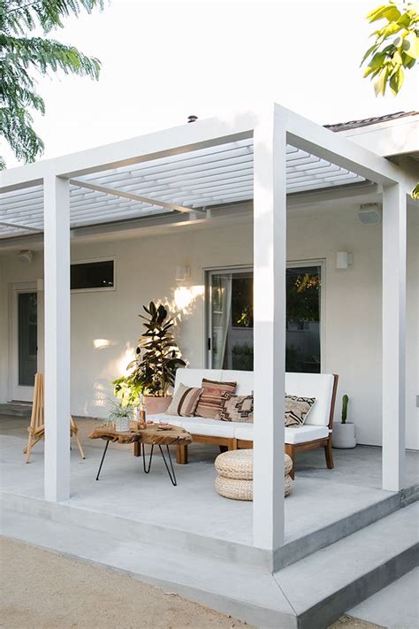 An Outdoor Living Area With White Furniture And Plants