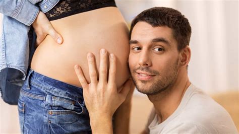 A Man Rubs A Womans Belly After She Rubbed His Pregnant Wifes Belly