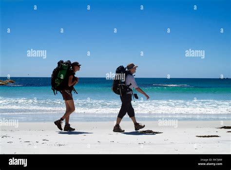 Guests Of Cradle Mountain Huts Walk Along A Remote Beach On The Bay Of