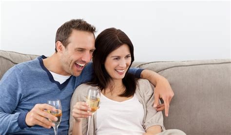 Premium Photo Cheerful Couple Drinking Champagne On The Sofa