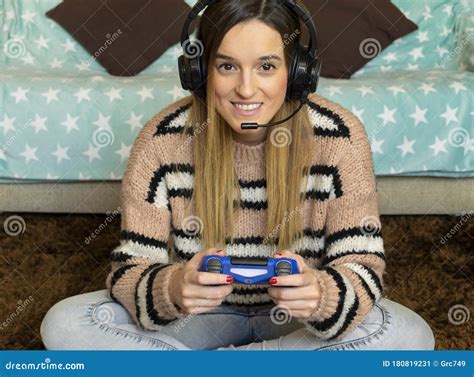 Attractive Gamer Girl With Headphones Plays With A Wireless Gamepad