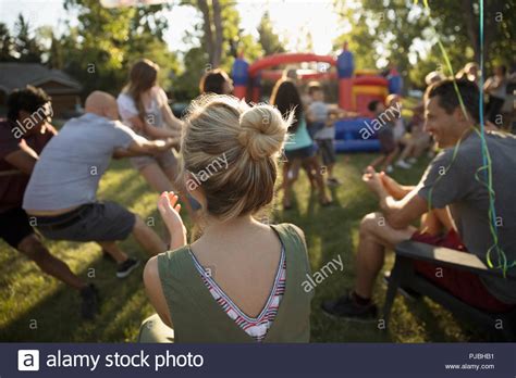 Woman Clapping Watching Neighbors Playing Tug Of War At Summer