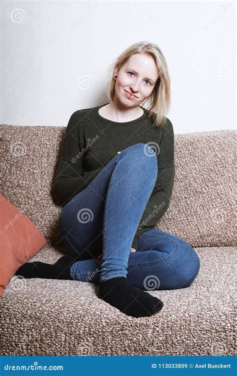 junge frau die zu hause auf sofa sitzt stockbild bild von entspannung pendel 113033809